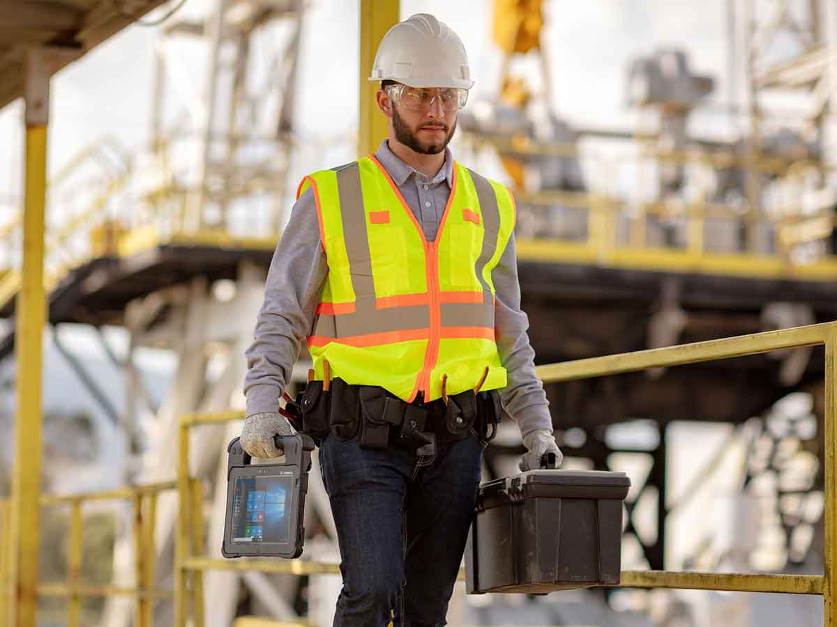field-mobility-photography-application-gas-communicating Utilities worker holding a zebra tablet walking on catwalk